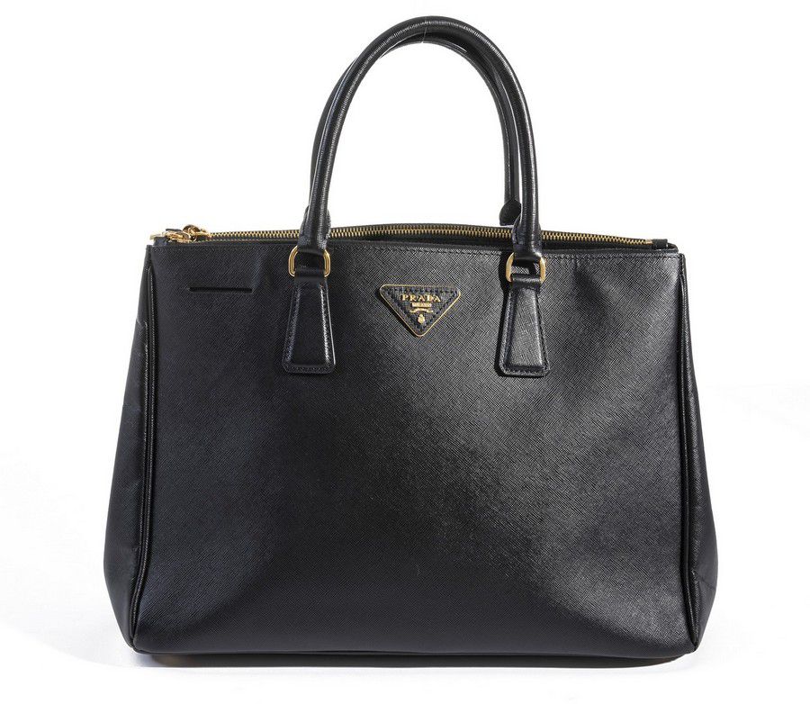 A Prada handbag, styled in a black coated canvas with gold… - Handbags ...