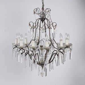 A glass chandelier, with a metal frame and glass pendants.…