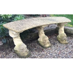 An old Haddonstone curved bench seat on triple dolphin fish…