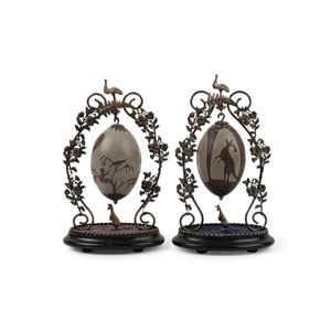A pair of carved emu eggs on Australian silver plated stands,…