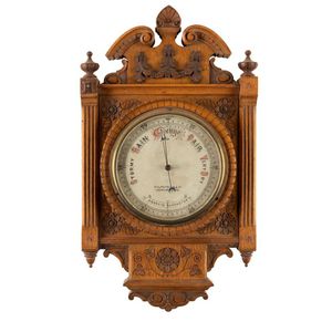 An antique wall barometer mounted in a finely carved oak frame,…