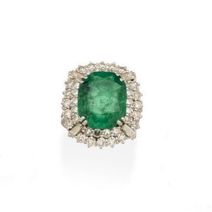 An emerald and diamond ring, centrally set with cushion-shaped…