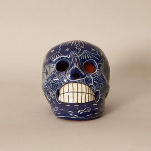 A cast ceramic Mexican skull, cobalt ground with all over hand…