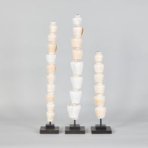 Three conch shell sculptures, shells stacked with a central…
