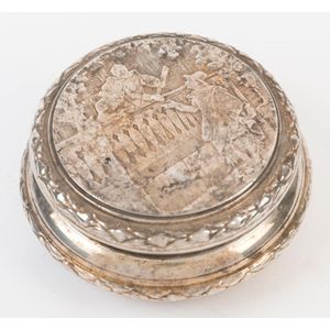 An antique circular silver jewellery box with engraved romantic…