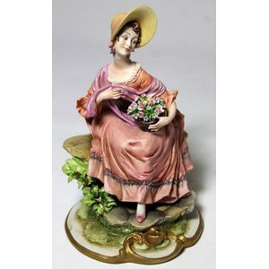 A porcelain figurine of a seated Rococo lady, 20th century, Italy