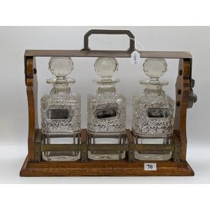 Victorian three bottle tantalus, English oak cradle with…