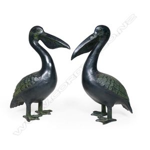 A characterful pair of bronze pelicans, modelled standing with…