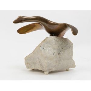 A small bronze sculpture of a bird, upon a raw travertine base,…