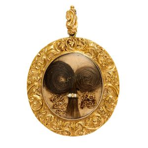 Gold Memorial locket, circa 1900; the oval surround of scroll…