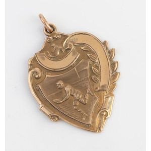 An Australian gold football medallion, stylised with scroll…
