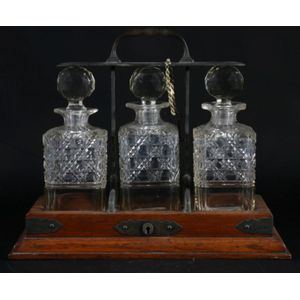 An oak tantalus, containing three cut crystal decanters, width…