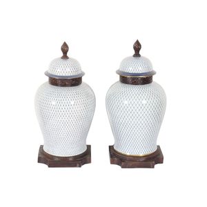 Pair of lidded urns with blue netted design on a crackled white…
