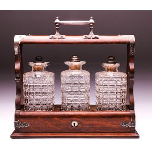 Oak tantalus with three cut glass decanters with silver on…