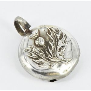 A sterling silver rattle pendant, featuring a thistle, few…