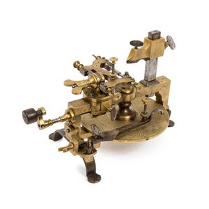 A brass watchmaker's gear cutting engine, with ebony handle and…