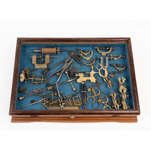 A display case containing assorted brass watchmakers callipers,…