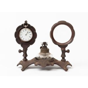 A cast iron night pocket watch stand with magnifying glass and…