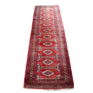 A small hand knotted Bukhara runner, the central panel with…