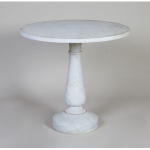 A white marble garden table, the circular top on a baluster…