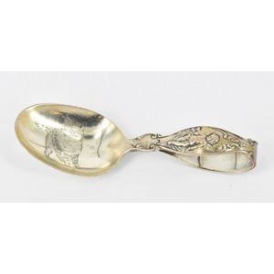 An American sterling silver baby spoon, 1894, featuring a…