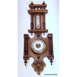 An antique walnut wall barometer, late 19th century, in an…