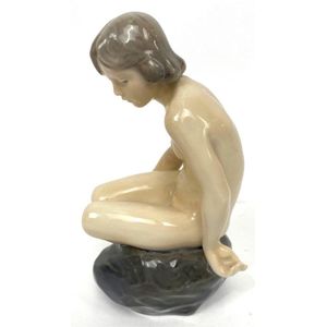 A Royal Copenhagen figure of naked young girl seated on a rock,&hellip;