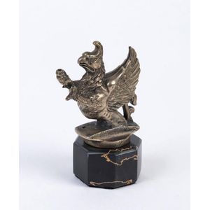 A griffin car mascot, silvered cast metal on late black marble…