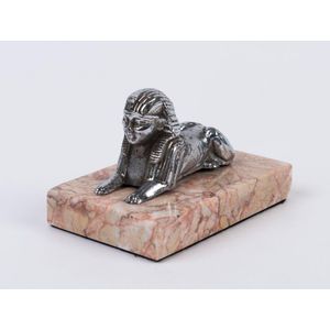 A sphinx chromed metal car mascot on pink marble plinth, circa…