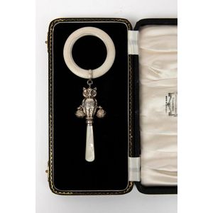 A mother of pearl handled silver owl rattle with bone teething…