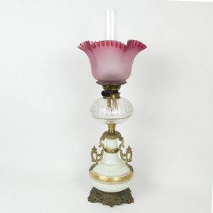 A Victorian kerosene lamp, the cream and gilt glass baluster…