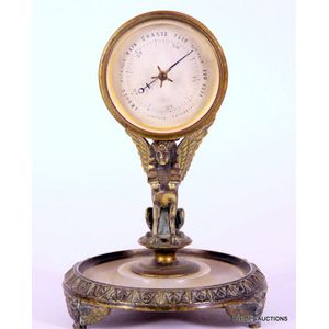 An antique bronze Egyptian revival table Barometer, the aneroid…