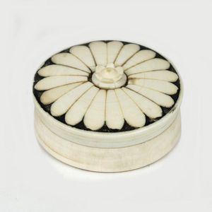 A small ivory pill box, circular, the lid with a radiating…
