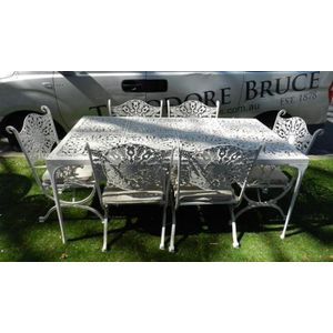 An outdoor white painted metal rectangular table with six…