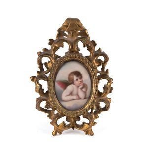 A miniature painting on porcelain of a cherub, in fine gilt…