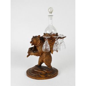 A Black Forest carved decanter stand, c.1900, carved as a bear…