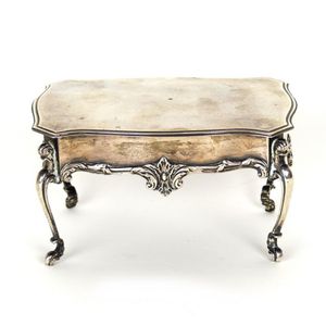 A small silver trinket box in the form of a French table the…