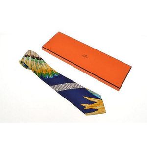 A silk tie by Hermes, styled with feathers on a blue background,&hellip;