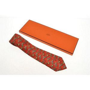 A silk tie by Hermes, styled with horses on a red background,&hellip;