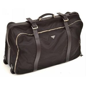 A suitcase by Prada, styled in black nylon with black trim,…