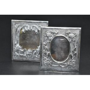 A pair of sterling silver miniature photo frames decorated with…