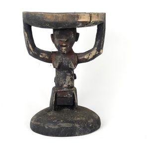 A Melanesian carved wood stool, the circular top supported on a…