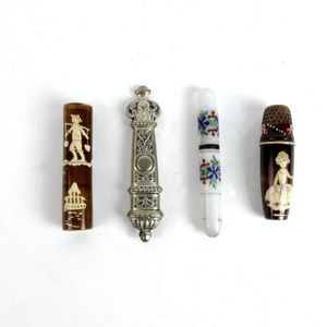 Four old needle cases, one painted milk glass, the other silver…
