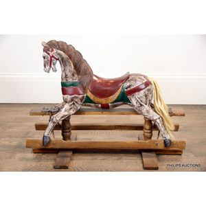 A vintage wooden rocking horse, the painted horse in a…
