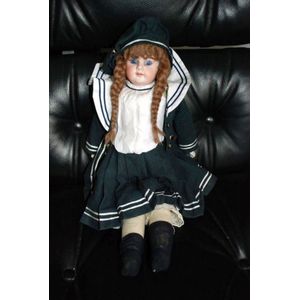A German porcelain headed doll, glass eyes, four teeth upper,…