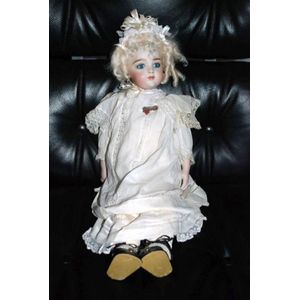 A Marg Herron porcelain headed doll, glass eyes, closed mouth,…