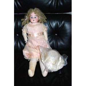 A porcelain headed doll, glass eyes, four teeth upper, kid…