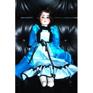 A German porcelain headed doll, glass eyes, five teeth upper,…