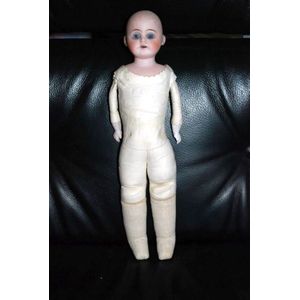 A porcelain headed baby doll, glass eyes, five teeth upper, kid…