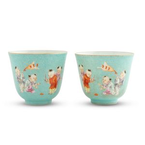 A pair of Chinese turquoise ground famille-rose boys cups,…